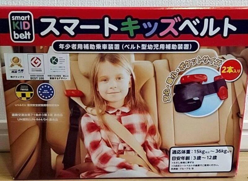 スマートキッズベルトのパッケージ写真。車に乗った子どもが装着している様子と、製品の特徴、安全基準マーク、対象年齢（3〜12歳）などが表示されている。
